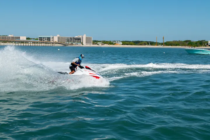 a man flying through the air while riding a wave in the ocean